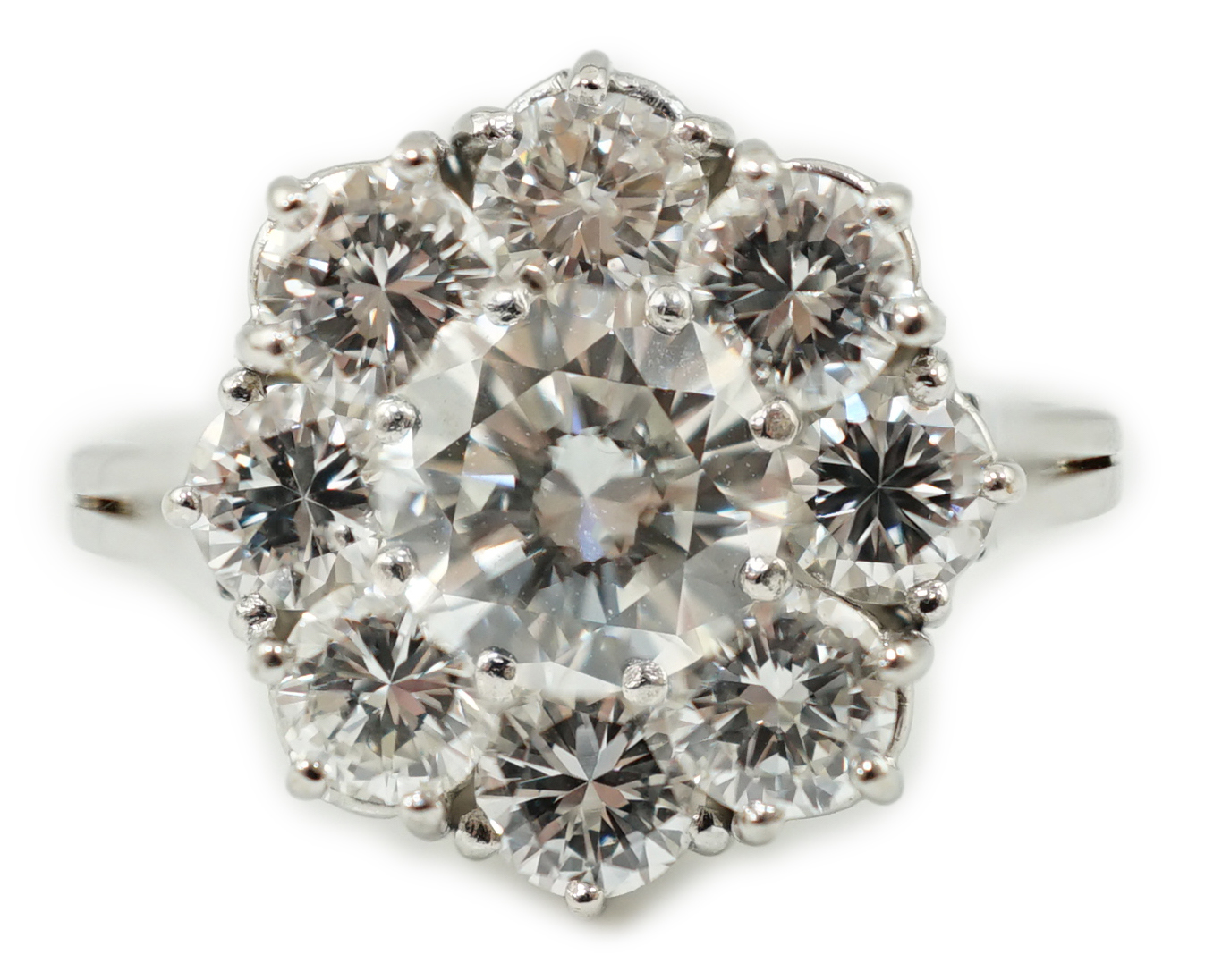 A modern 18ct white gold and round brilliant cut nine stone diamond set cluster ring
